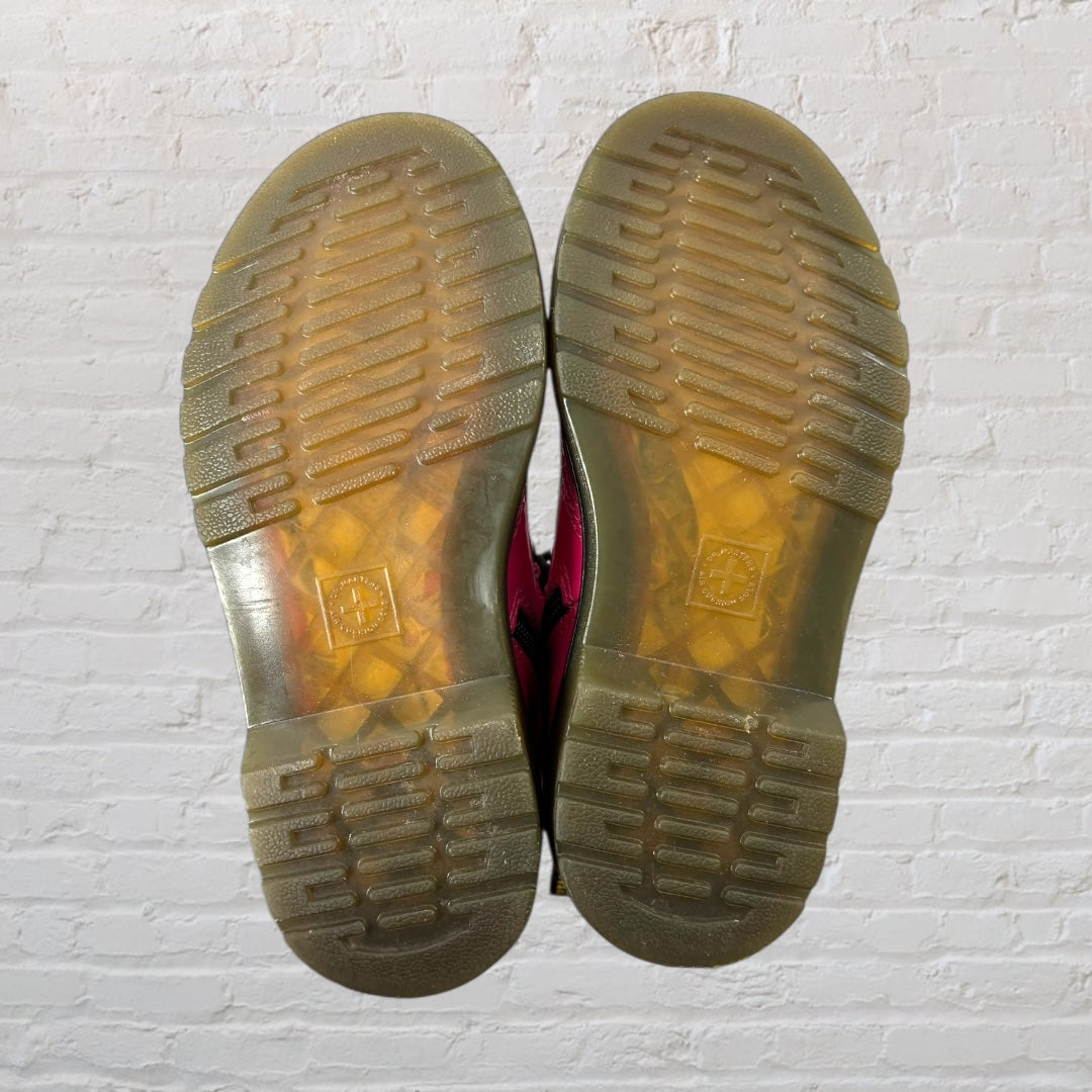 Bright pink lace-up combat boots with black laces and soles, featuring a pull tab at the back.