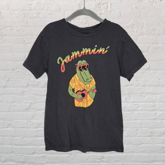 Black T-shirt with a colorful graphic of a crocodile wearing sunglasses and a floral shirt, holding a guitar.