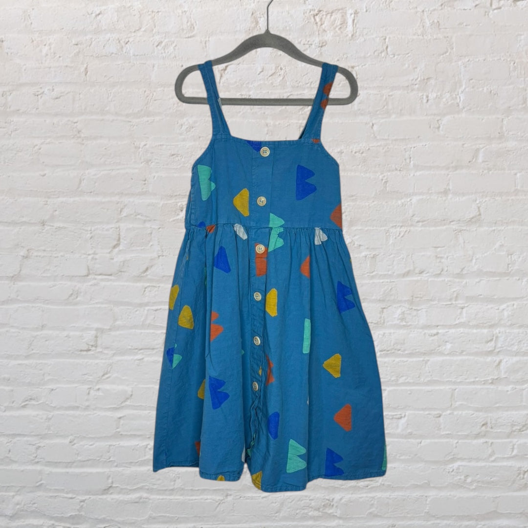 Blue sundress with shoulder straps and colorful geometric shapes, featuring a button-front design, hanging on a black hanger.