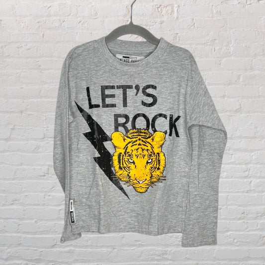 Grey sweatshirt featuring a graphic 'Let's Rock' print with a yellow tiger and black lightning bolt.