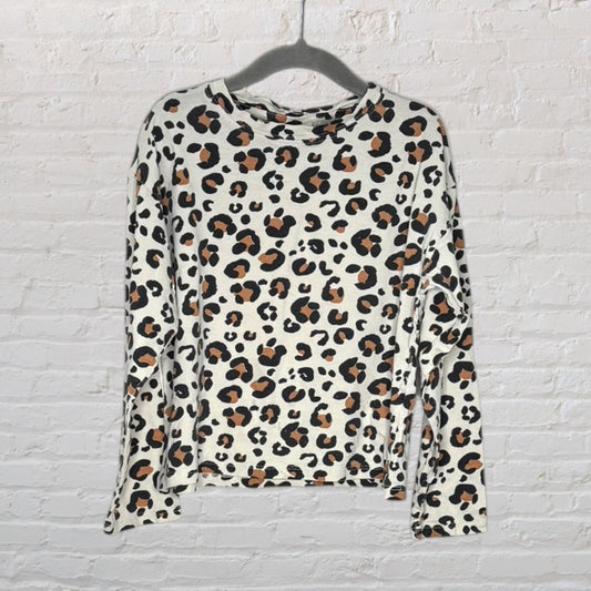 Women's long sleeve top with leopard print pattern in white, brown, and black, hanging on a hanger.
