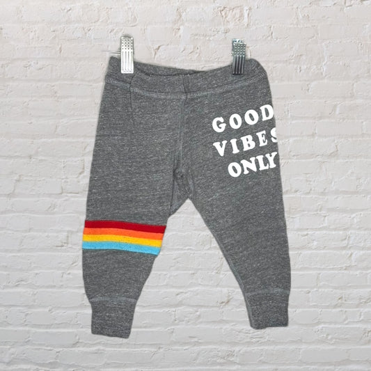 Gray sweatpants with 'Good Vibes Only' text and rainbow stripe on leg.