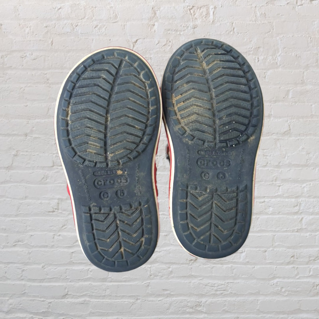 Navy blue kids sandals with red straps, featuring a sporty design and perforated details.