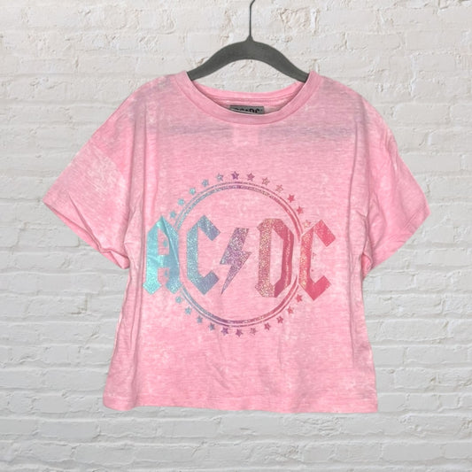 Pink AC/DC T-shirt with glittery logo and a star-bordered circle design on a hanger.
