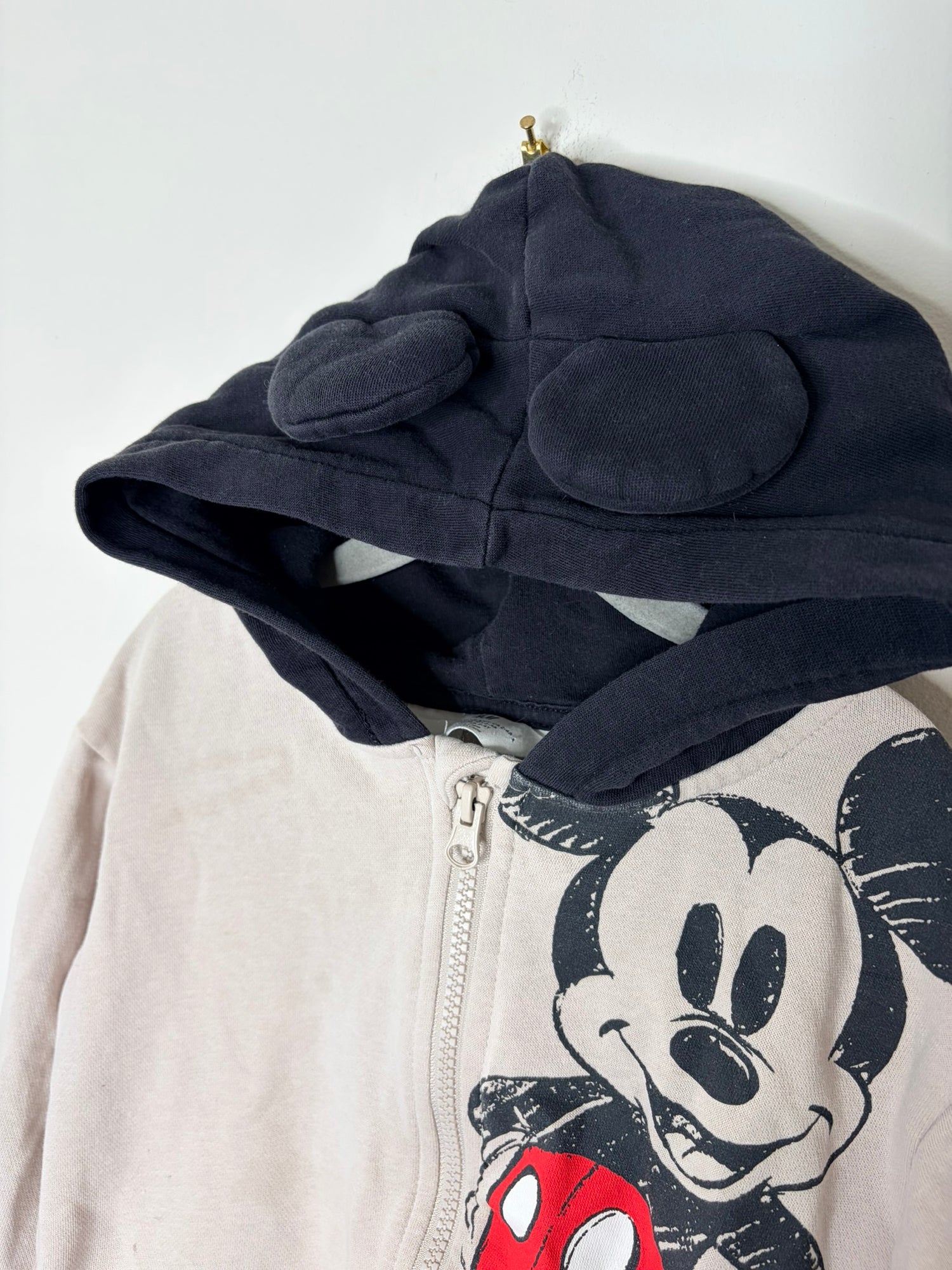 Beige zip-up hoodie with Mickey Mouse graphic and black hood with ears.