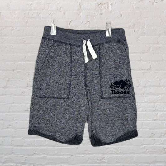 Gray fleece shorts with drawstring and Roots logo hanging on a hanger.