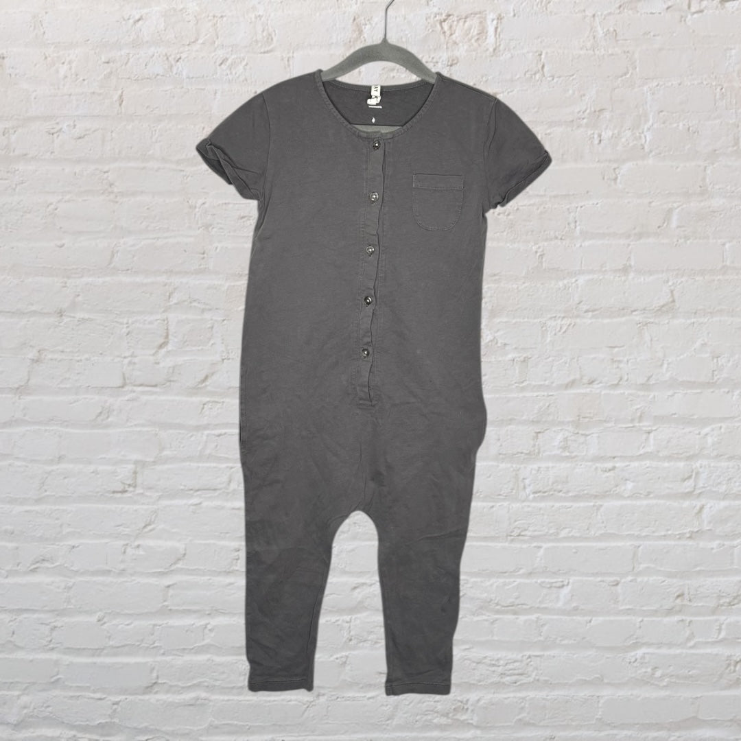 Dark grey kids button-up romper with short sleeves and a chest pocket, hanging on a hanger.