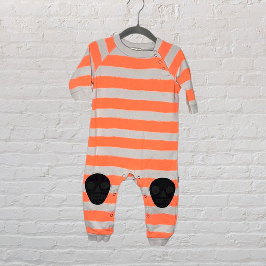 Baby onepiece with orange and grey stripes featuring black skull patches at the knees, hanging on a hanger.