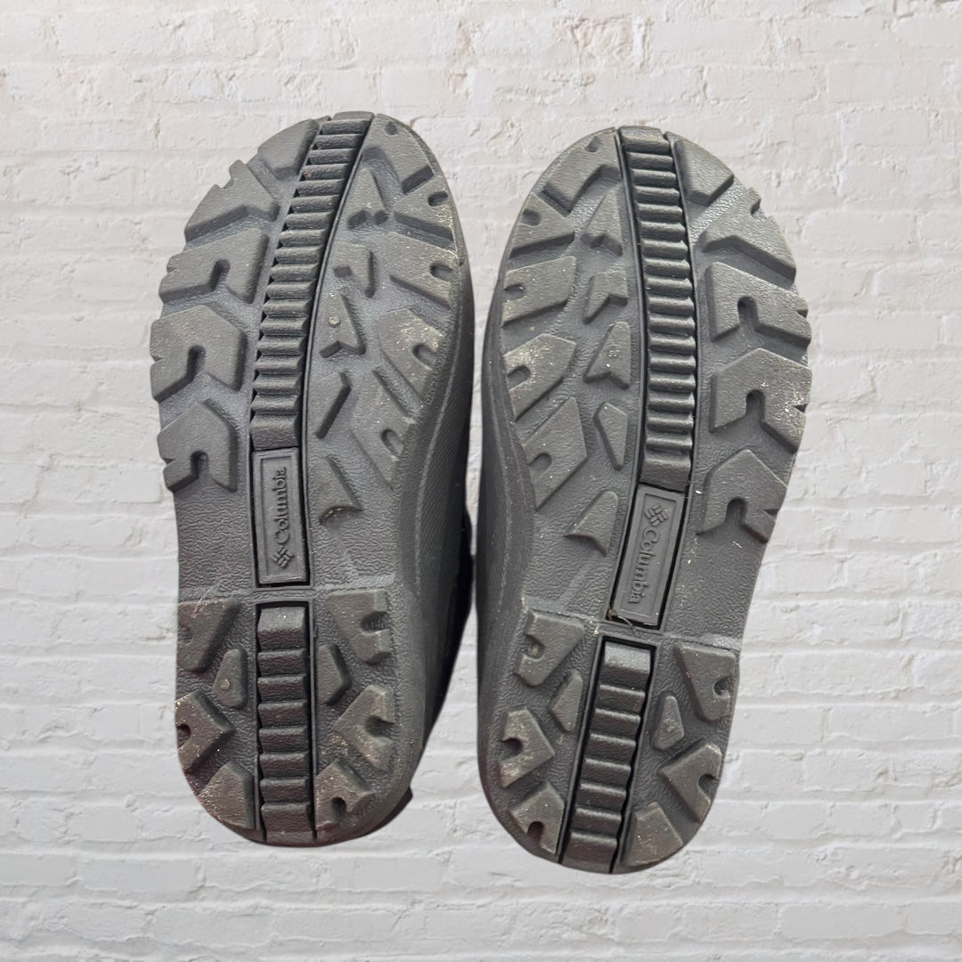 Columbia waterproof winter boots in purple and black with yellow drawcords, featuring a durable sole and warm lining.