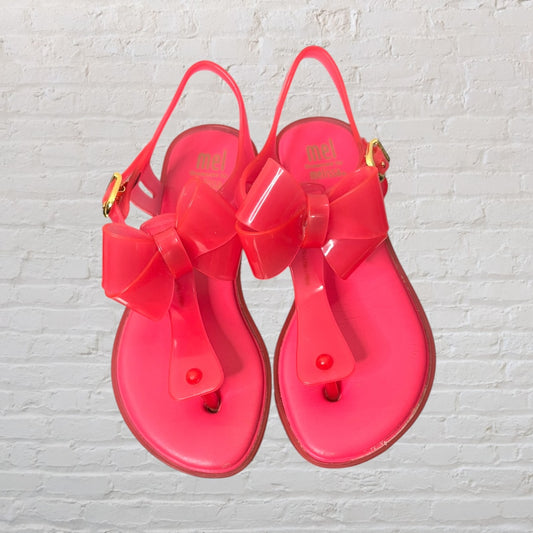 Hot pink jelly sandals with large bows and gold buckles by Mel by Melissa.