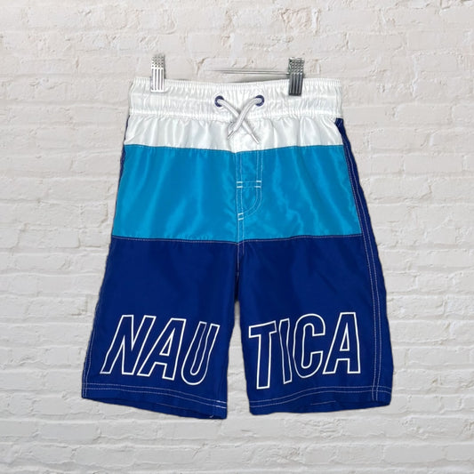 Men's colorblock swim shorts with blue and white panels and 'NAUTICA' logo, featuring an elastic waistband and drawstring.