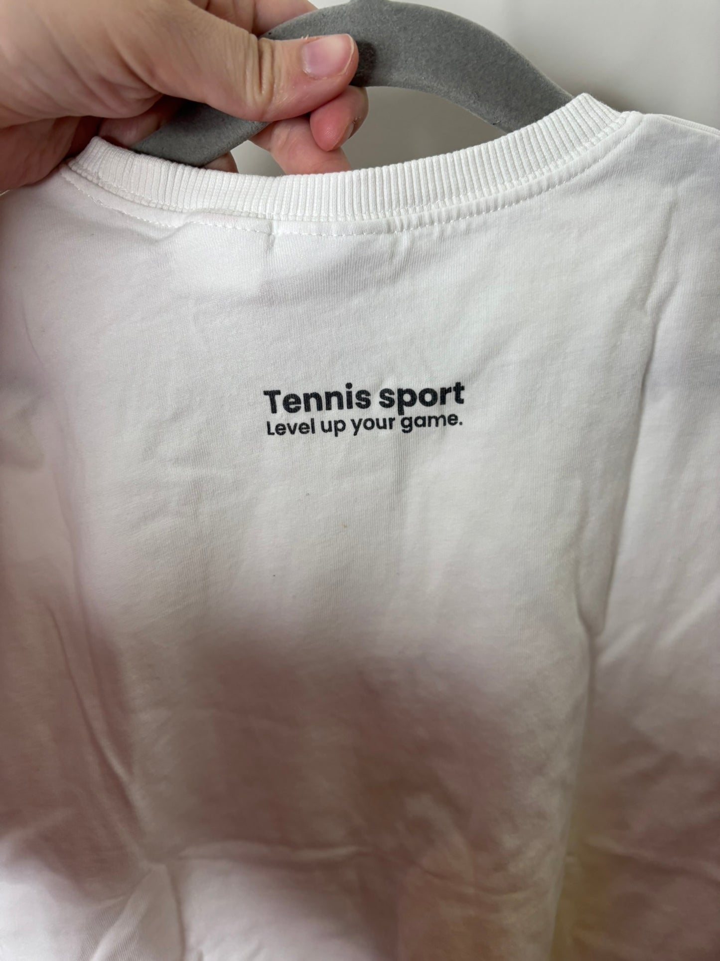 White T-shirt with 'Très Sportif Tennis Pro Classics' and tennis ball graphic design.
