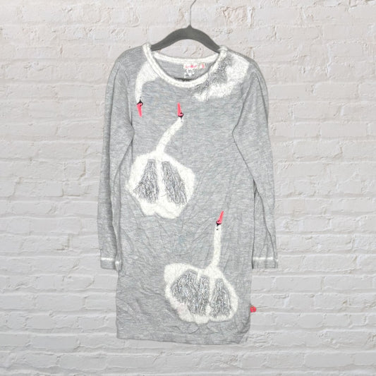 Grey knit dress with white swan appliqué details and pink accents, hanging on a black hanger.