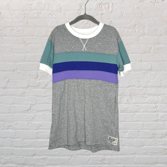 Colorblock T-shirt with grey, teal, blue, and purple sections, featuring a white crewneck and sleeves, hanging on a hanger.