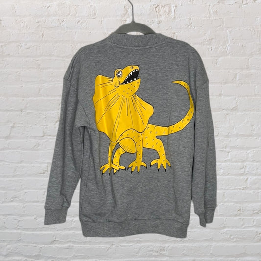Grey sweatshirt with a large yellow dinosaur graphic on the back, hanging on a hanger.