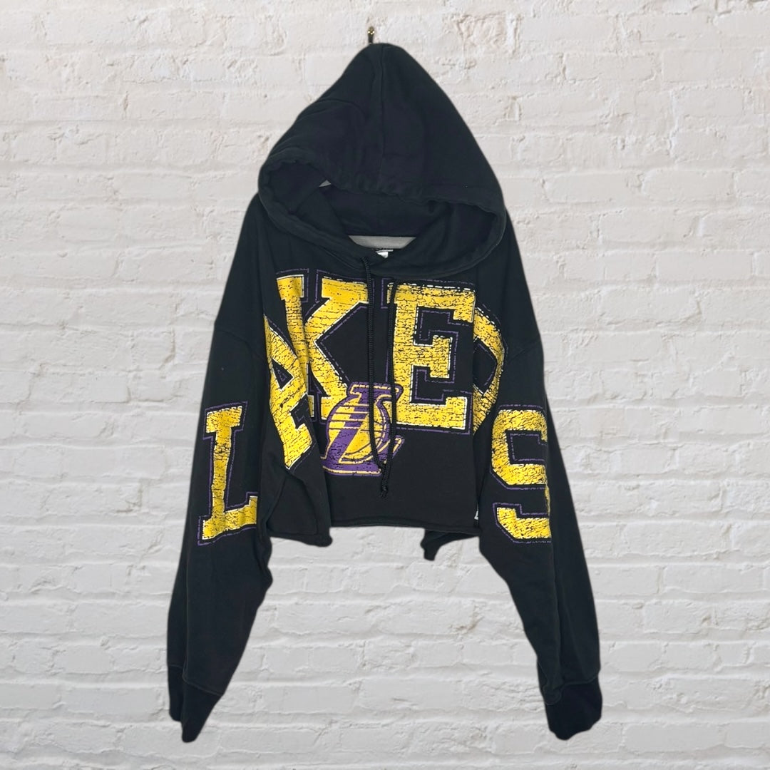 Black cropped hoodie with yellow and purple Lakers logo and text design.