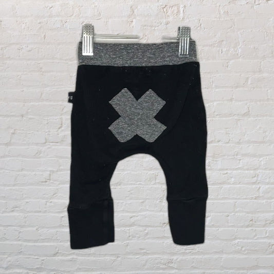 Black harem pants for kids with a grey waistband and an X patch on the back.