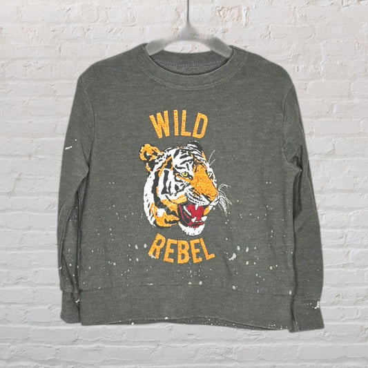 Olive green sweatshirt featuring a 'Wild Rebel' text and tiger graphic, with paint splatter details.