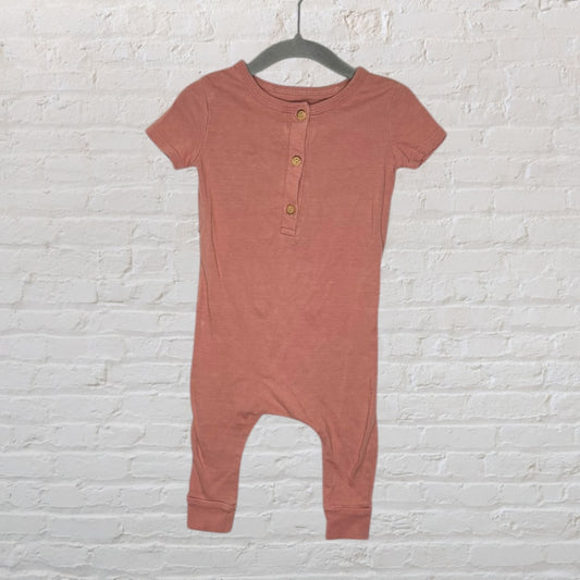 Dusty pink short sleeve romper with button-up front hanging on a hanger.