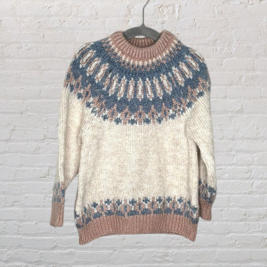 Nordic patterned knit sweater in ivory with blue and brown geometric designs, displayed on a hanger.