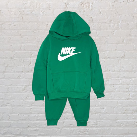 Green Nike hoodie and sweatpants set with white logo, displayed against a white brick background.