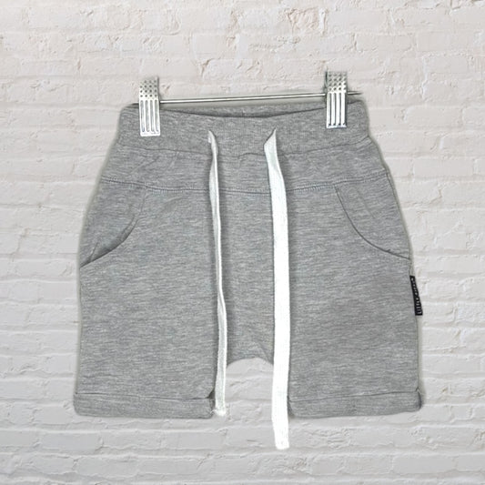 Gray casual shorts with white drawstring, featuring side pockets and a comfortable fit, displayed against a white brick background.