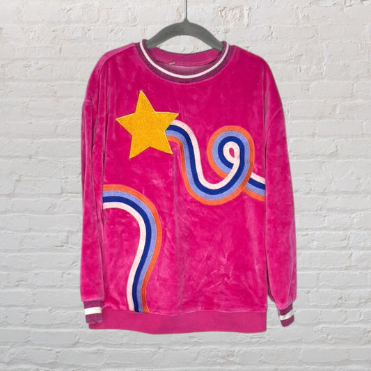 Pink retro sweatshirt with a yellow star and multicolored wavy lines, displayed on a hanger.
