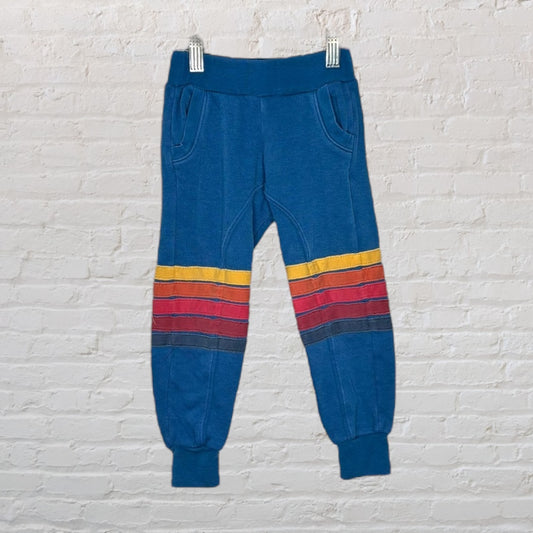 Blue jogger pants with colorful red, yellow, and navy stripes near the knees.