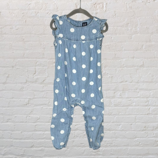 Light blue denim romper with white polka dots and ruffled sleeves, displayed on a hanger.