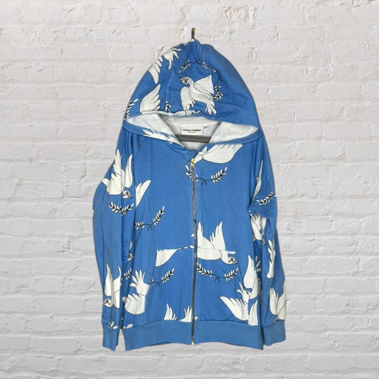 Blue zip-up hoodie featuring a white bird print, designed by Mini Rodini, displayed against a brick wall.