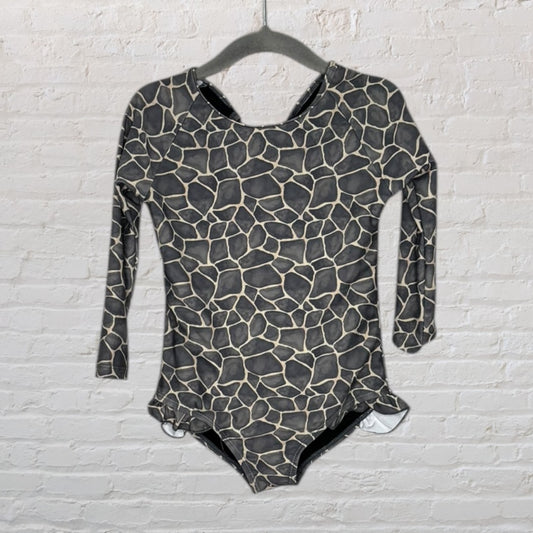Long sleeve giraffe print bodysuit in black and beige hanging on a hanger.