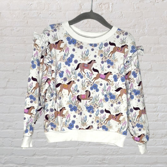 White sweatshirt with colorful horse and floral print and ruffle details on the shoulders.