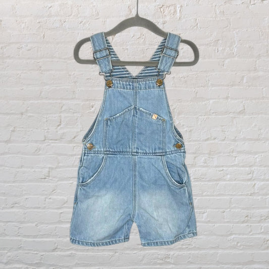 Light blue denim overalls shorts with adjustable straps and pockets, hanging on a hanger.