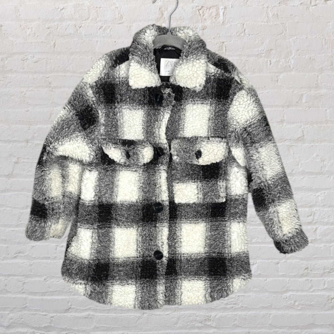 Black and white plaid Sherpa shacket with button-down front and chest pockets, hanging on a hanger.