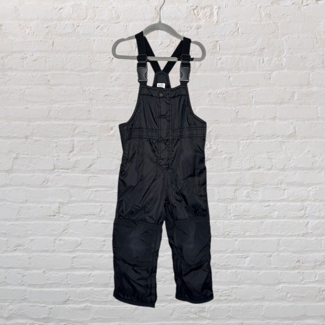 Children's black snow bib overalls with adjustable straps hanging on a hanger.