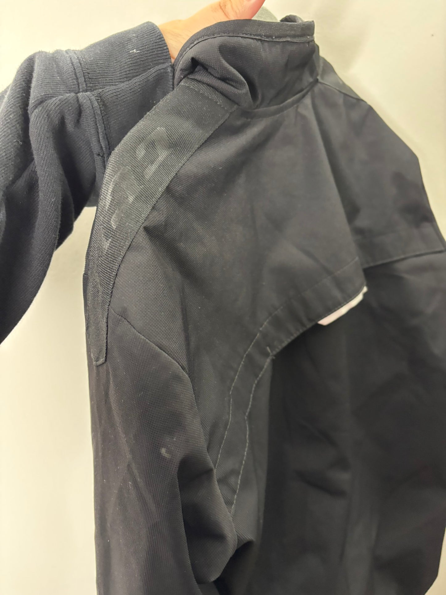 Black CCM full zip jacket with two zippered pockets and logo on the shoulder, displayed on a hanger.