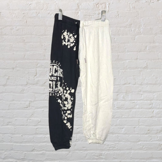 Two-tone joggers with a rock and roll graphic on the black half and plain white on the other side.