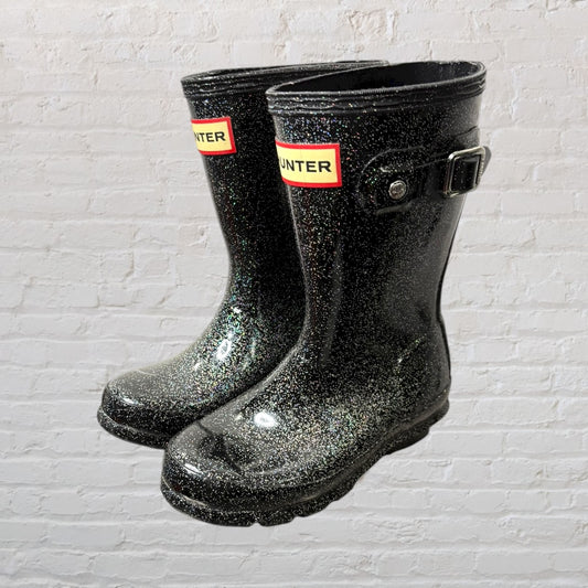 Black glitter Hunter rain boots with buckle design, featuring logo on the top front.