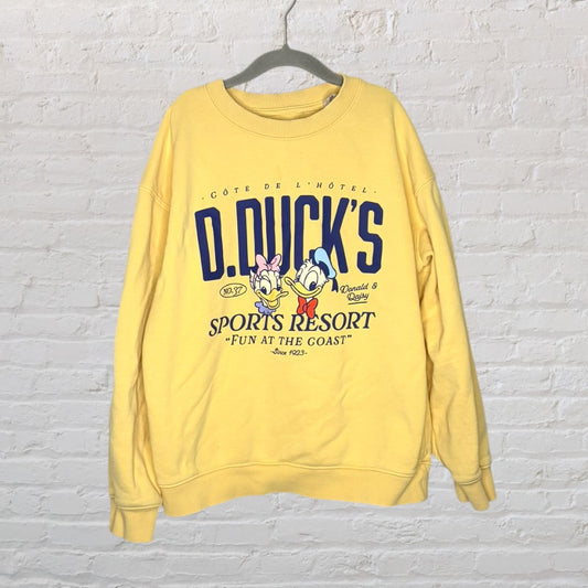 Yellow sweatshirt featuring a cartoon print of Donald and Daisy Duck with 'D. Duck's Sports Resort' text.