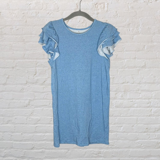 Light blue dress with ruffled sleeves, hanging on a black hanger against a white brick wall.