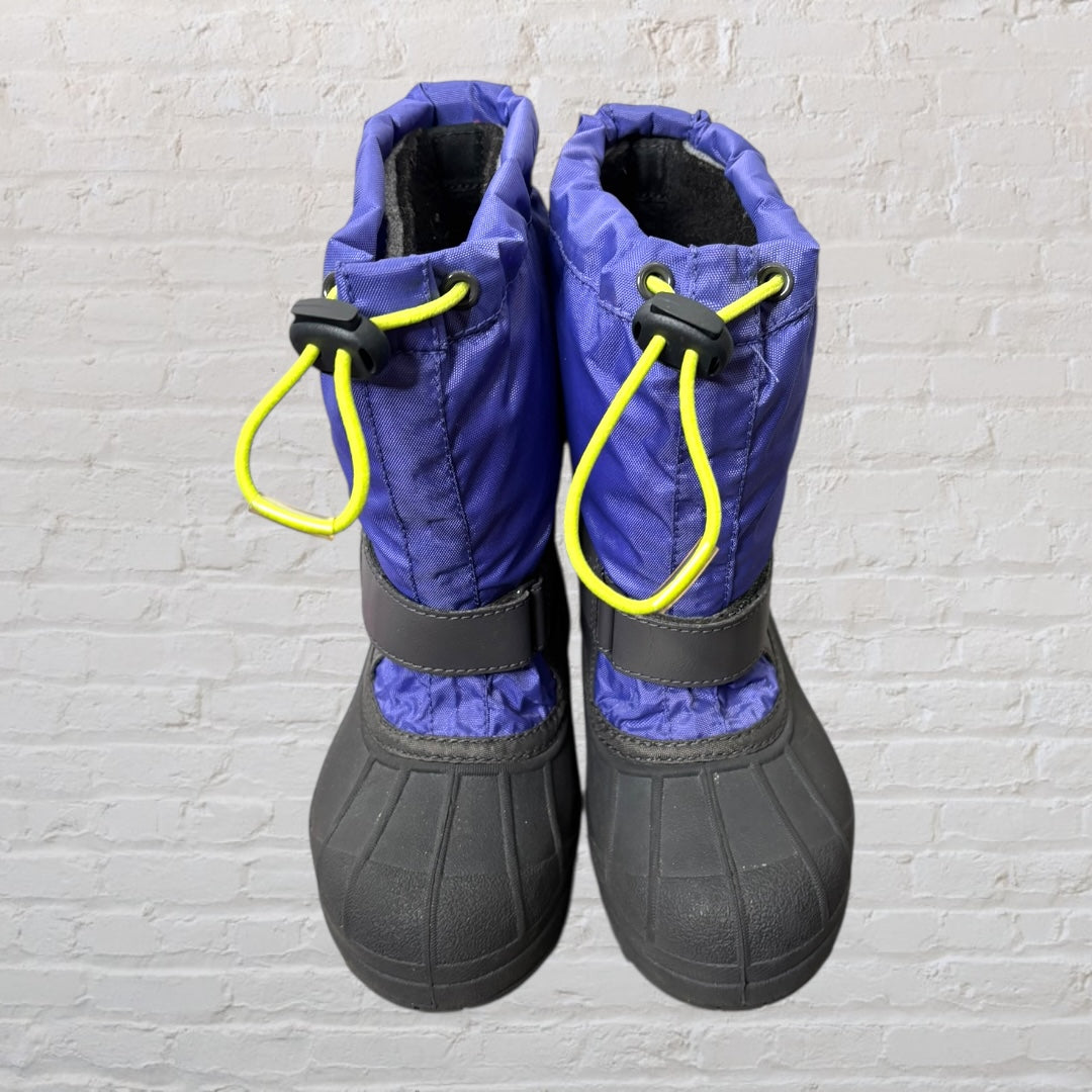 Columbia waterproof winter boots in purple and black with yellow drawcords, featuring a durable sole and warm lining.