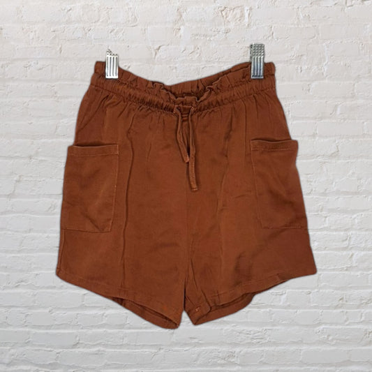 Brown casual shorts with a drawstring waist and front pockets, hanging on clips.