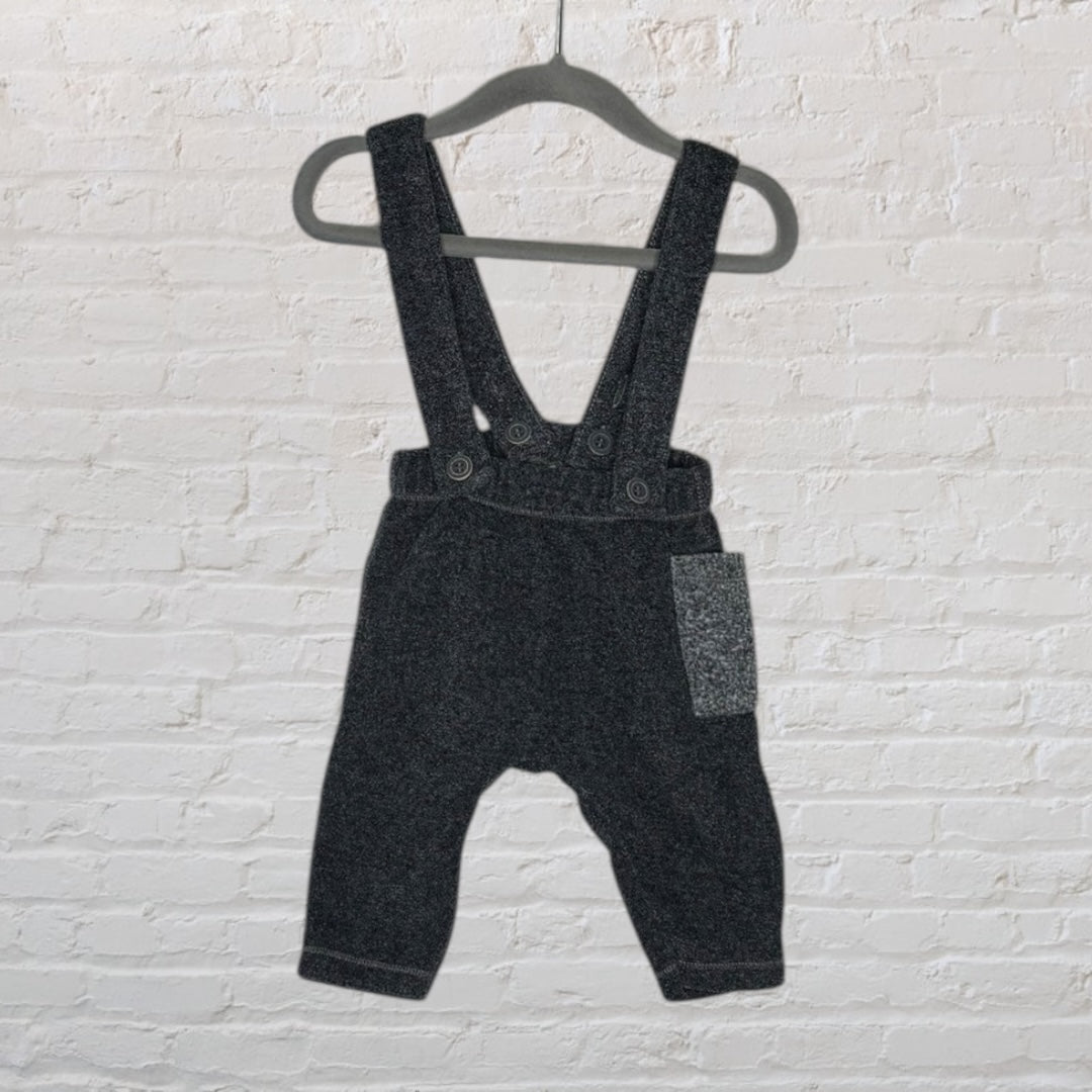 Dark grey baby wool suspender pants with button closures and a front pocket, hanging on a hanger.