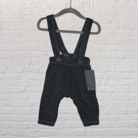 Dark grey baby wool suspender pants with button closures and a front pocket, hanging on a hanger.