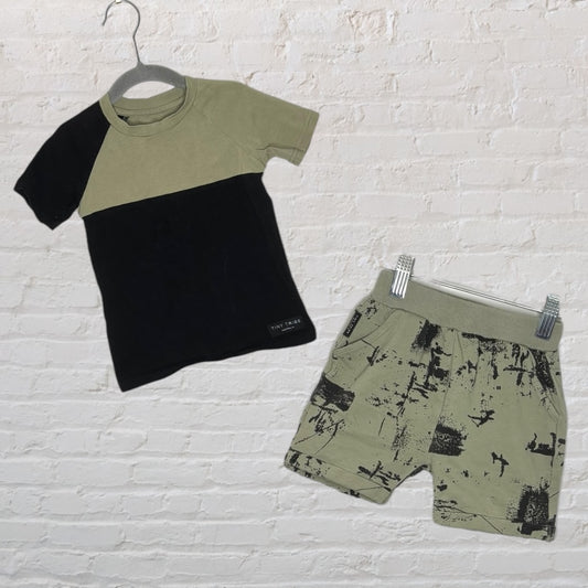 Unisex outfit set featuring a two-tone tee in black and olive green with matching printed shorts in olive green with black splatter.