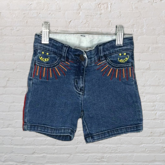Blue denim shorts with orange embroidered sunburst pattern and yellow smiley face on pockets, by Lee.