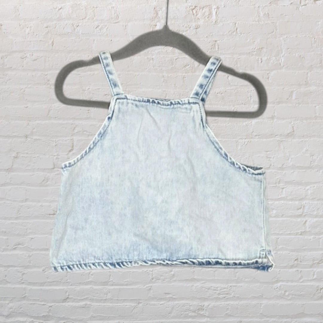 Light blue denim crop top with thick straps, displayed on a hanger.