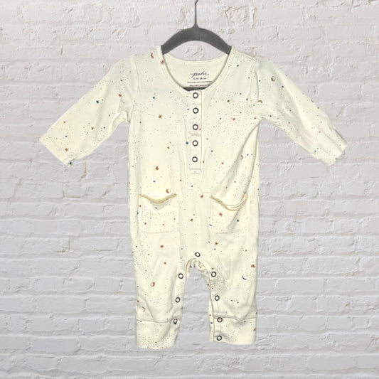 Cream-colored onesie with multicolored star print, featuring buttons down the front and two pockets.