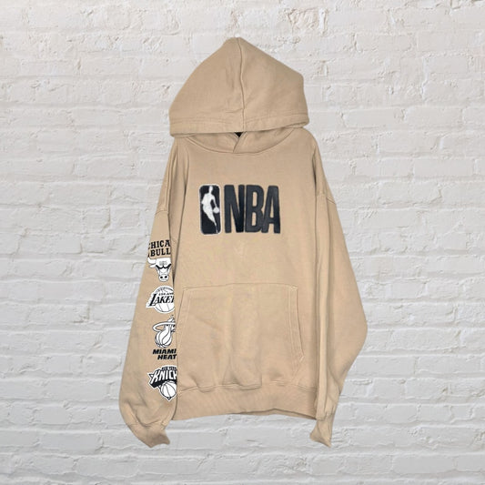 Beige NBA hoodie featuring team logos on the sleeve and NBA logo on the front.
