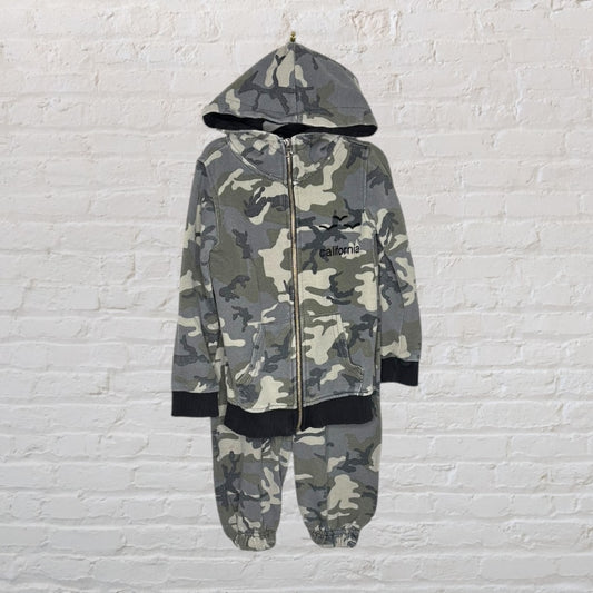 Grey camouflage hoodie and sweatpants set with 'California' text on the hoodie, displayed against a white brick wall.